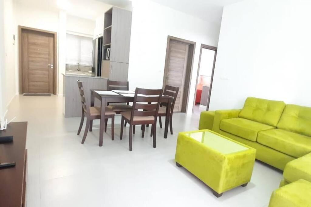een woonkamer met een groene bank en een tafel bij 2 Bedroom Apartment close to all amenities in Highlands