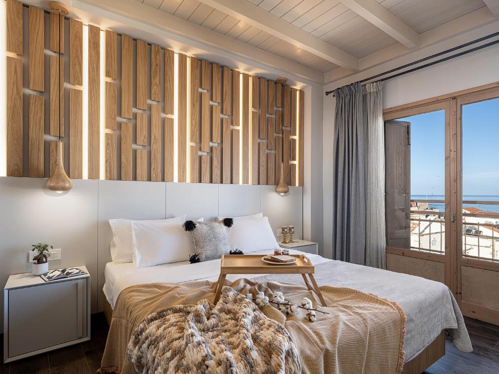 a bedroom with a bed with a view of the ocean at Elia Bettolo Hotel in Chania