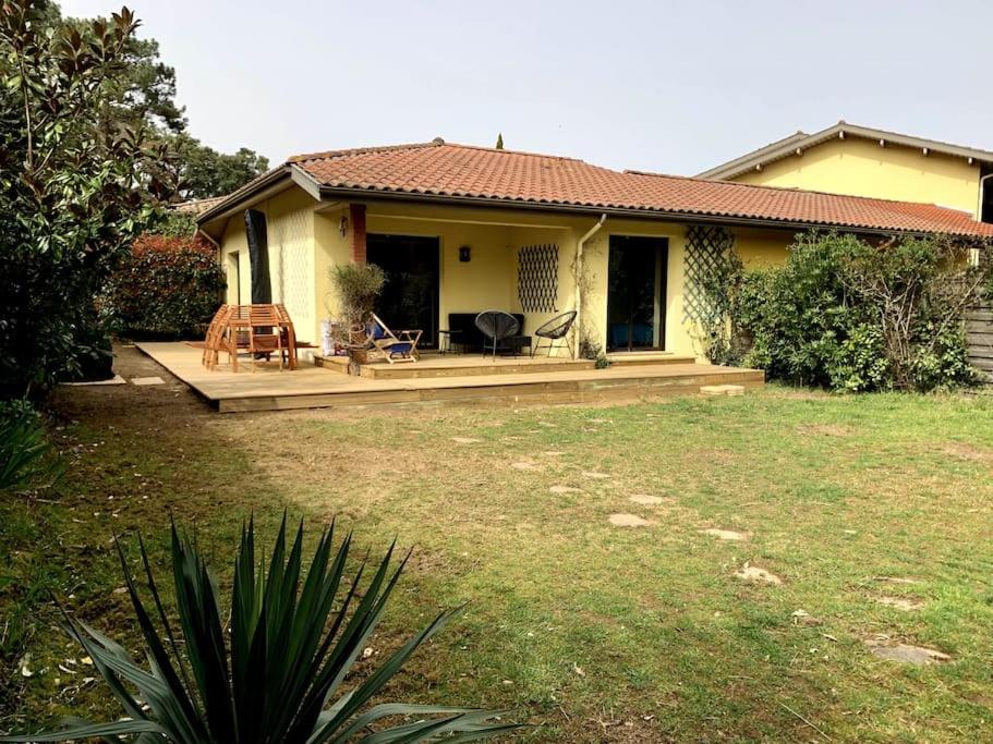 una pequeña casa amarilla con terraza en un patio en Villa Patio à 800 m de la plage, en Seignosse