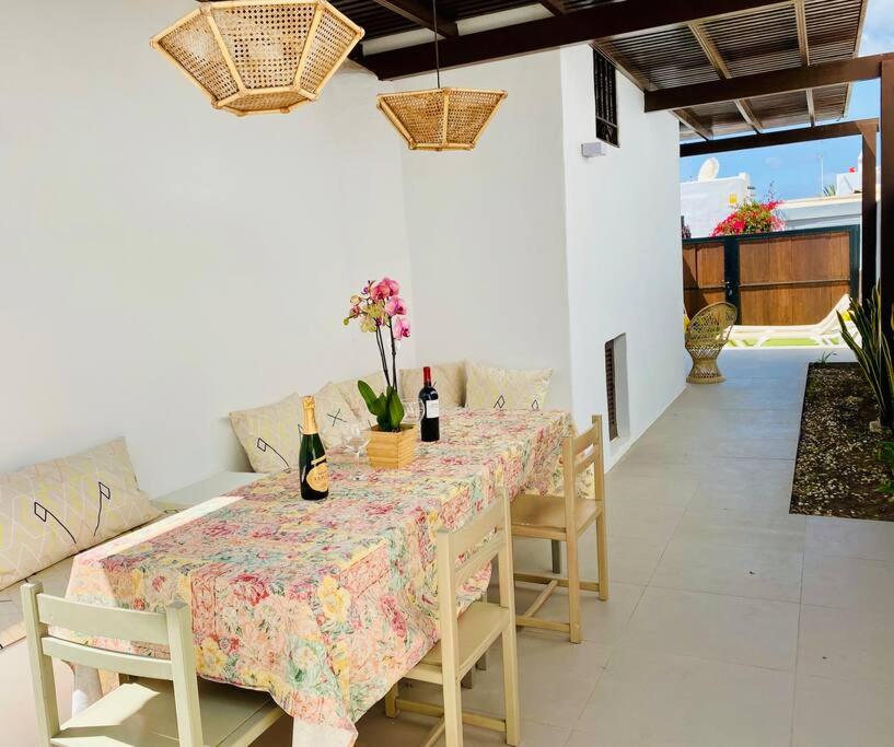 a dining room table with two bottles of wine at Villa muy cerca de la Playa. in Tías