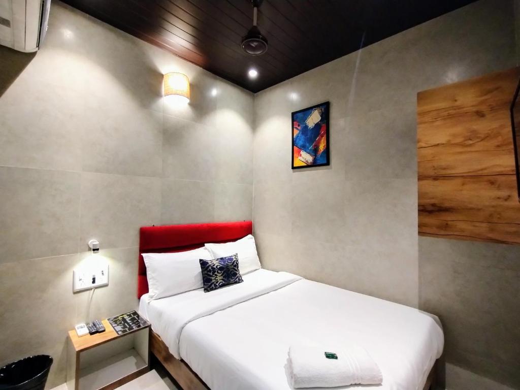 a bedroom with two beds and a red headboard at Hotel Eros - Near Mumbai International Airport T2 in Mumbai