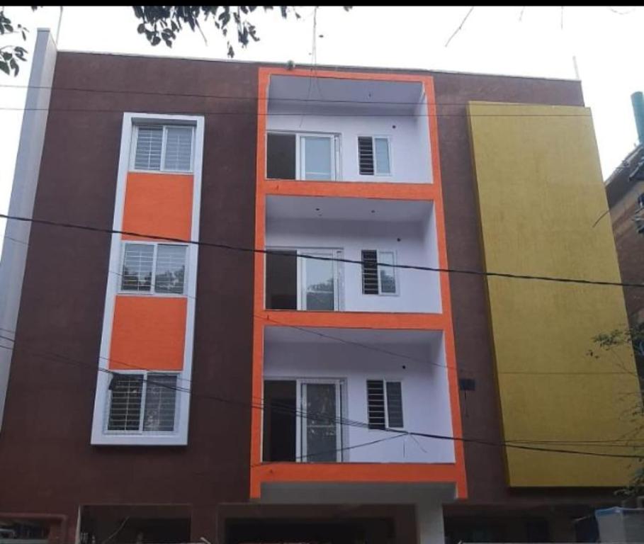 um edifício de apartamentos com janelas cor-de-laranja e brancas em Castle Dollars em Bangalore