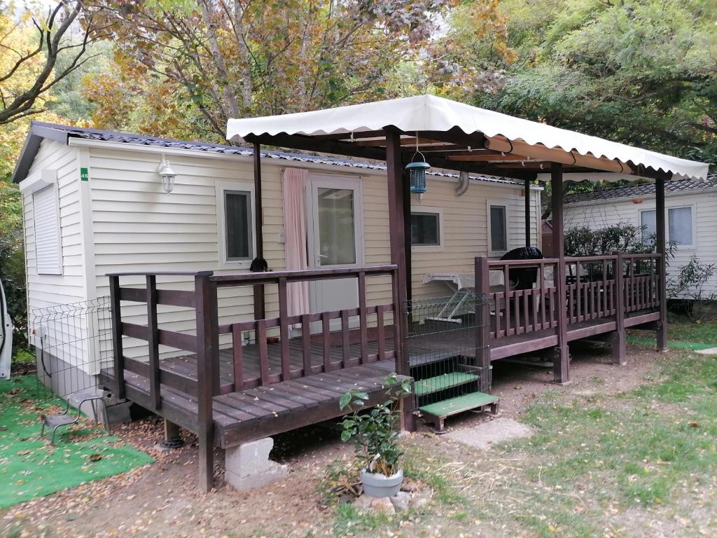 une maison avec un kiosque et un banc dans l'établissement mobil home dans camping 3 etoiles mas de lastourg avec piscine,snack,, à Villefranche-de-Conflent