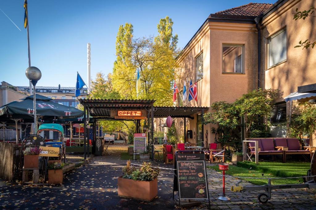 uma rua com mesas e cadeiras e um edifício em Reimersholme Hotel em Estocolmo