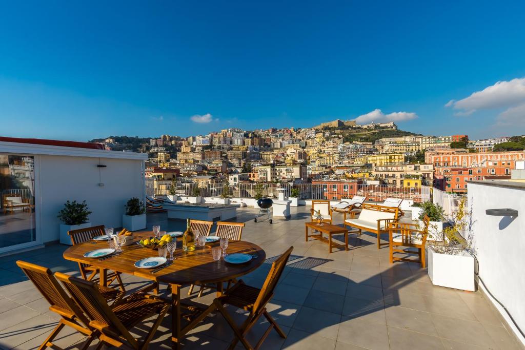 um pátio com mesas e cadeiras e vista para a cidade em Poerio Rooftop Luxury apartament em Nápoles