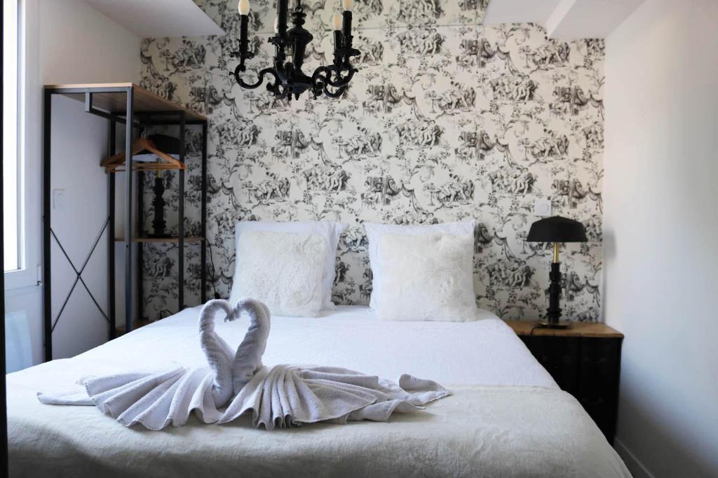 a bedroom with a bed with a heart decoration on it at L'antichambre, neuf avec jardin à 100m de la mer in Donville-les-Bains