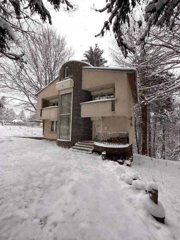 a building with snow on the ground in front of it at Villa Alexa in Borovets