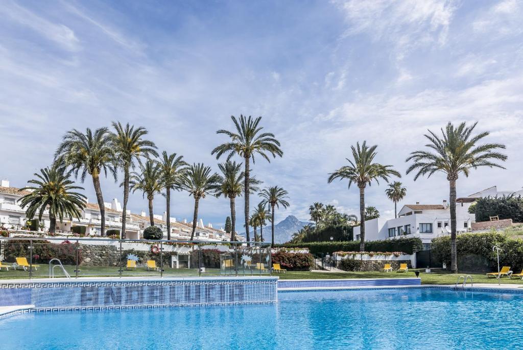 a large swimming pool with palm trees in the background at AGC28- Andalucia Garden Club by Roomservices in Marbella