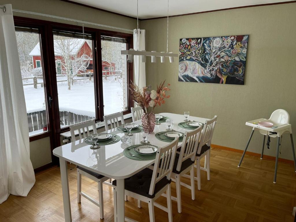 Ferienhaus in Broakulla mit Sauna في Broakulla: غرفة طعام مع طاولة بيضاء وكراسي