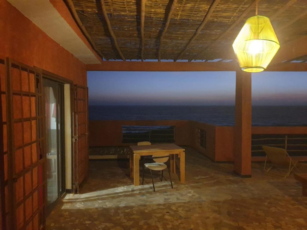 a room with a table and a view of the ocean at Chambres vue imprenable in Guéréo