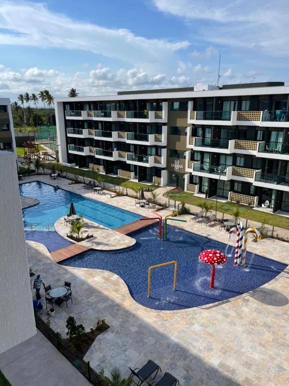 um grande edifício de apartamentos com piscina e parque infantil em Mana Beach Experience - Muro Alto - Flat Luxo 2 qtos em Porto de Galinhas