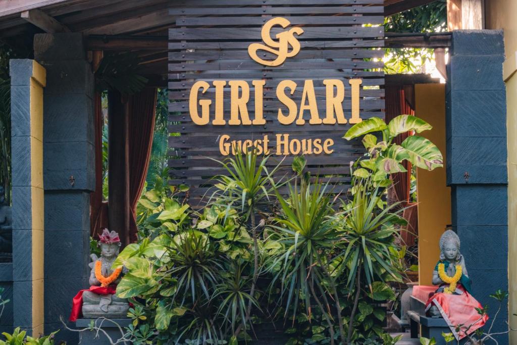 un panneau indiquant une maison d'hôtes dans un jardin dans l'établissement Giri Sari Guest House Pemuteran Bali, à Pemuteran