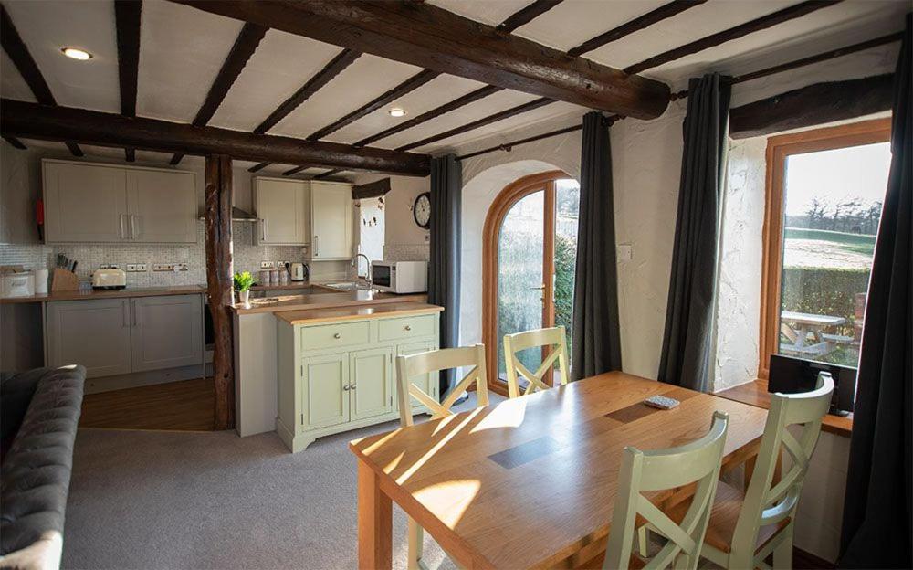 a kitchen and dining room with a wooden table and chairs at Garth Cottage, Castle Carrock, Nr Carlisle in Castle Carrock