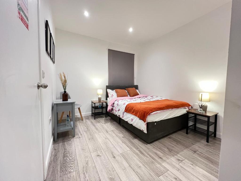 a bedroom with a bed and two night stands at Dunamis Staycation 4 in Croydon