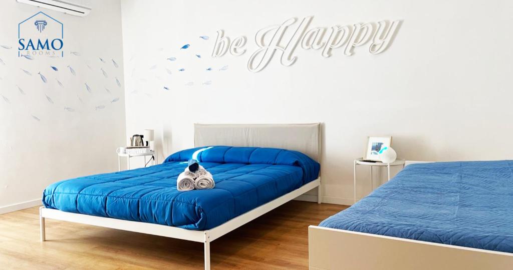 een slaapkamer met een blauw bed met een kat erop bij Samo Rooms in Pozzuoli