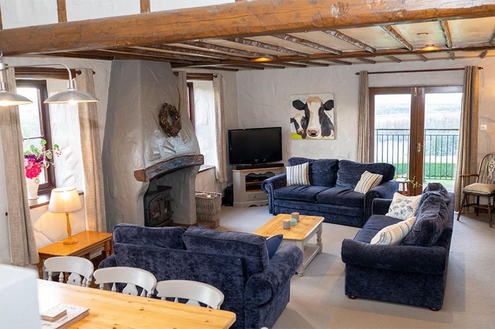sala de estar con sofás azules y chimenea en Mill Barn, Castle Carrock, Nr Carlisle en Castle Carrock