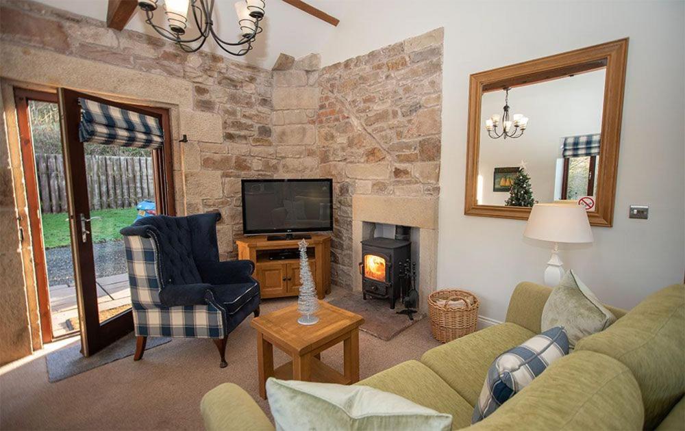 sala de estar con sofá y chimenea en Oak Cottage, Castle Carrock, Nr Carlisle en Castle Carrock
