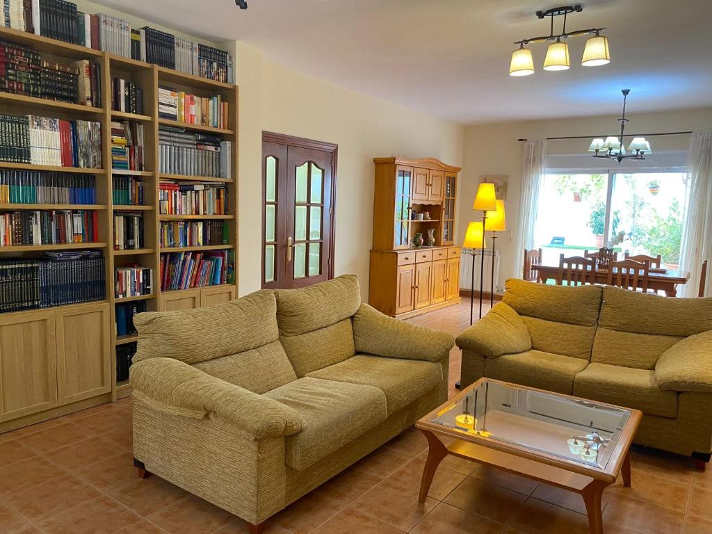 Sala de estar con 2 sofás y mesa de centro en CASA RURAL con Chimenea, Barbacoa, Terraza y Solarium, en Illar