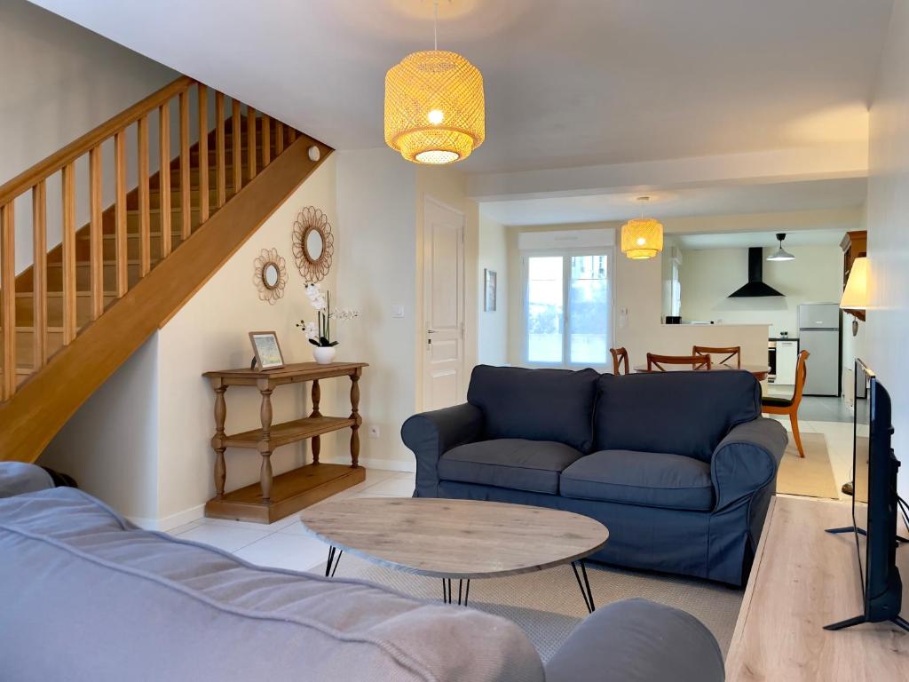 uma sala de estar com um sofá azul e uma mesa em Le Mulberry em Bayeux