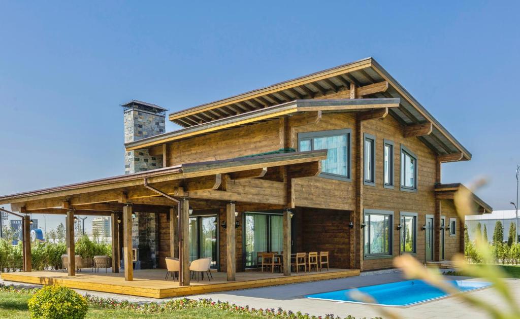 a wooden house with a pool in front of it at Eco Village in Samarkand