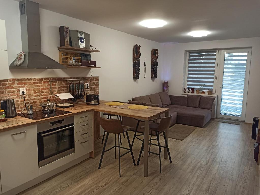 een keuken en een woonkamer met een tafel en een bank bij Severan New Appartement 2 in Martin