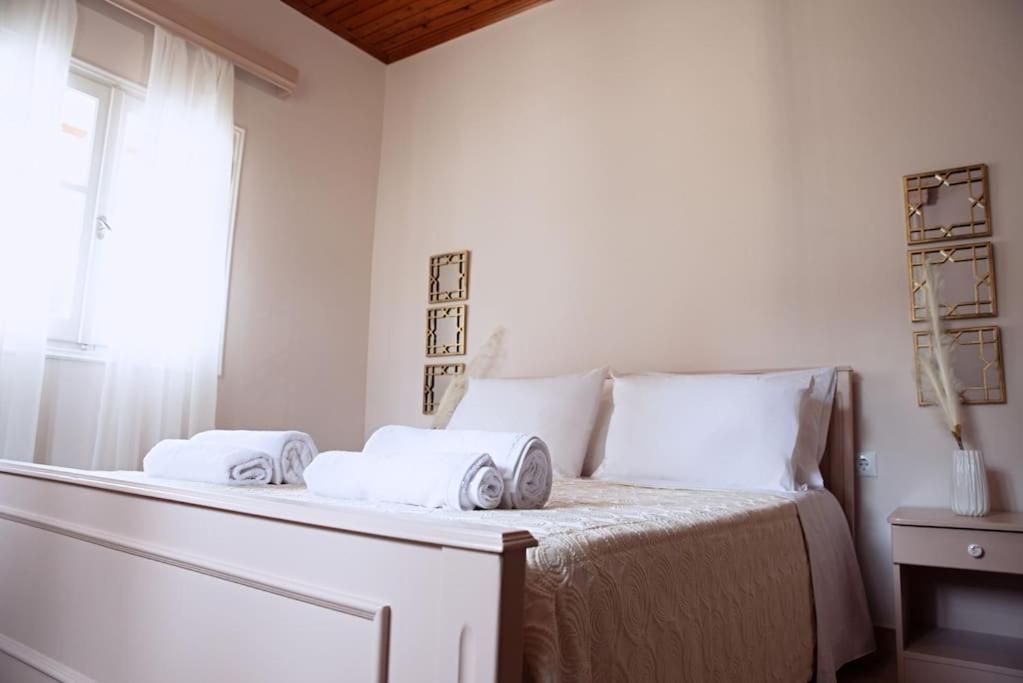 una camera da letto bianca con un letto e asciugamani di The Homey a Sidari