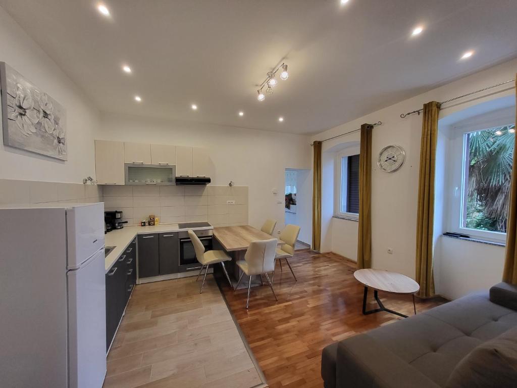Il comprend une cuisine et un salon avec une table et des chaises. dans l'établissement Apartment Lucky, à Opatija