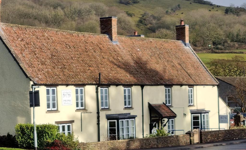 a white house with a brown roof on a street at Old Manor House in Axbridge