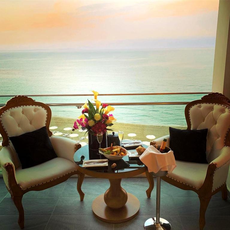 a room with two chairs and a table with a view of the ocean at The Ciao Stelio Deluxe Boutique Hotel - Adults Only in Larnaka