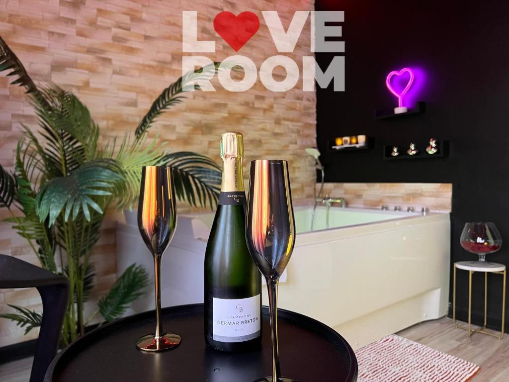 a table with two wine glasses and a bath tub at LOVE ROOM ou pas ! Chamalières in Chamalières