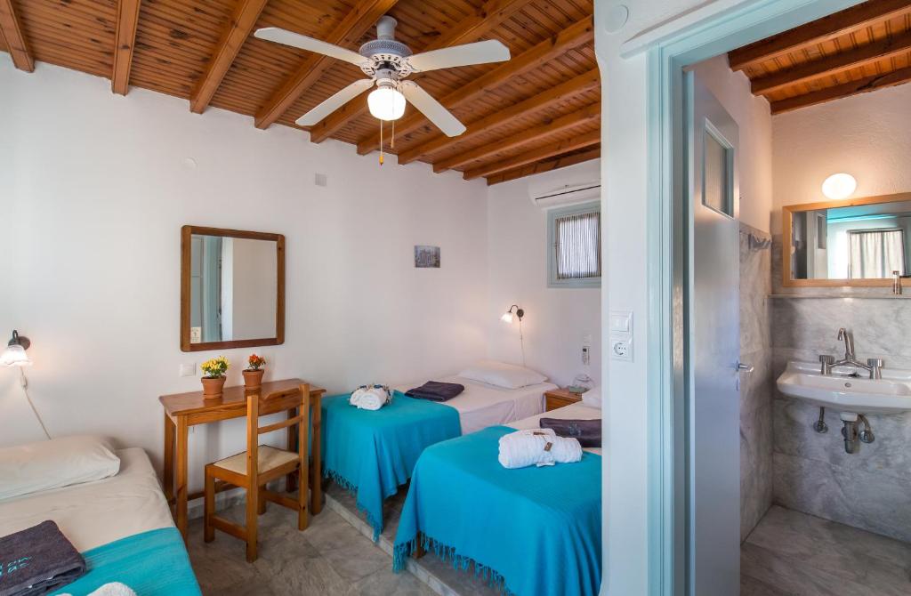 een slaapkamer met 2 bedden, een wastafel en een plafond bij Pension Marias in Mykonos-stad