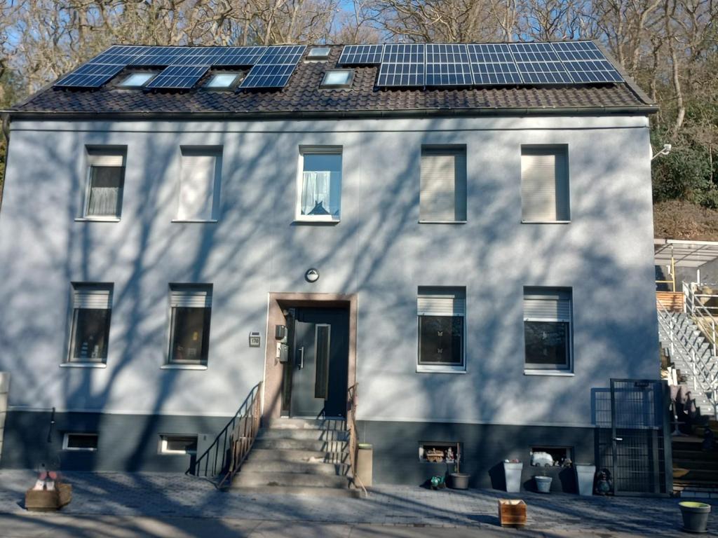 a white house with solar panels on the roof at Grüner Blick in Witten