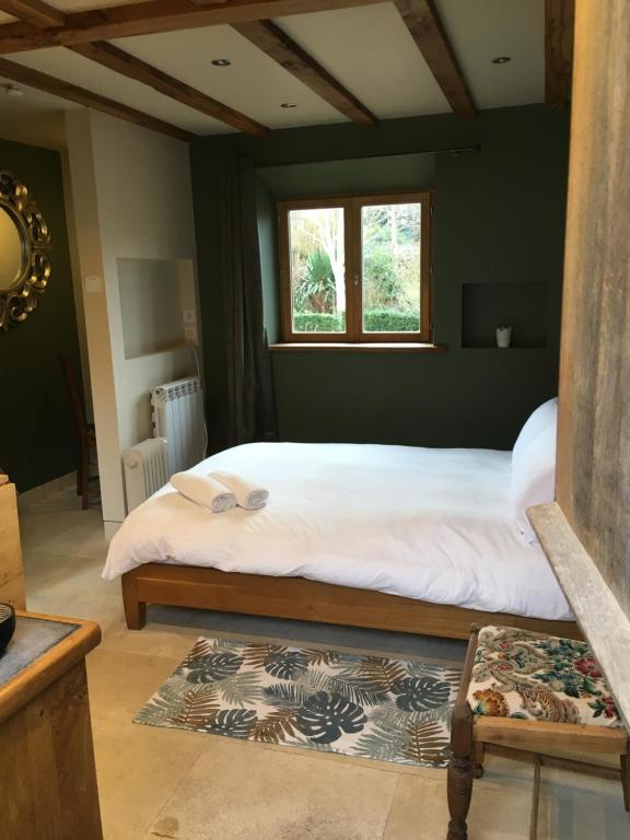 a bedroom with a large white bed with a window at Farmhouse B&B in Saint-Georges