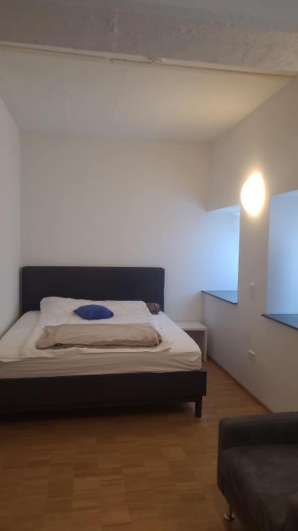 a bedroom with a bed with a blue pillow on it at Apartment Nordbergstrasse in Heilbronn