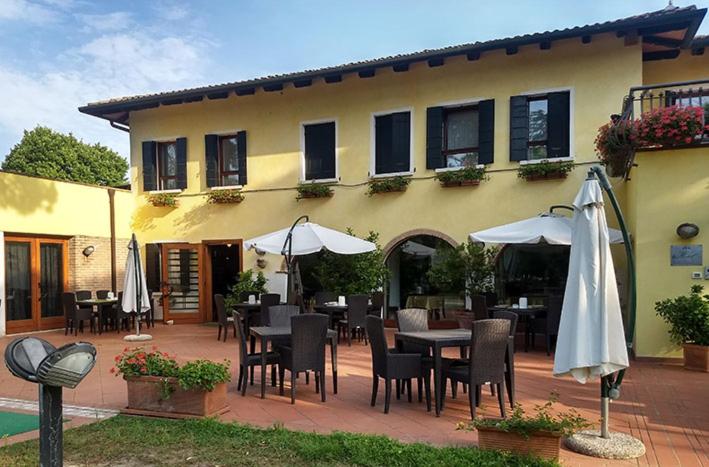 a patio with tables and umbrellas in front of a building at Il Ghebo in Cavallino-Treporti