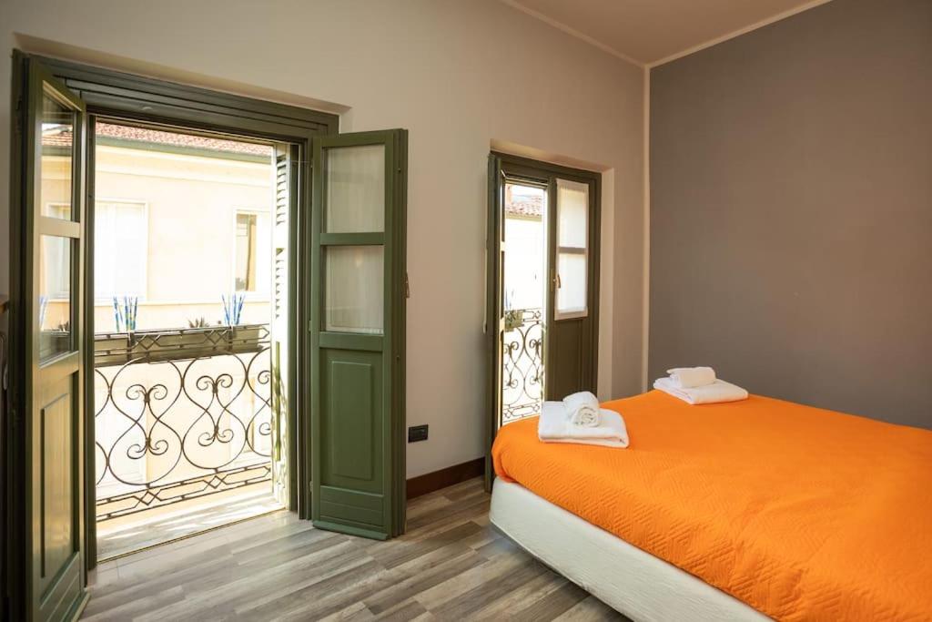 ein Schlafzimmer mit einem orangenen Bett und einem Balkon in der Unterkunft Appartamento Roma 55 in Mantua