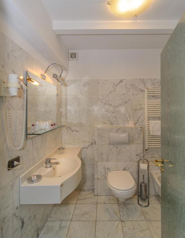 a white bathroom with a sink and a toilet at L'incanto Di Boccadarno in Marina di Pisa