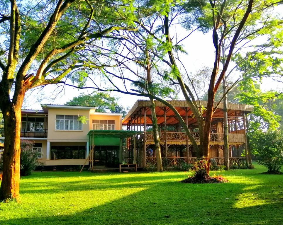 uma casa com um relvado verde em frente em Jinja Backpackers em Jinja