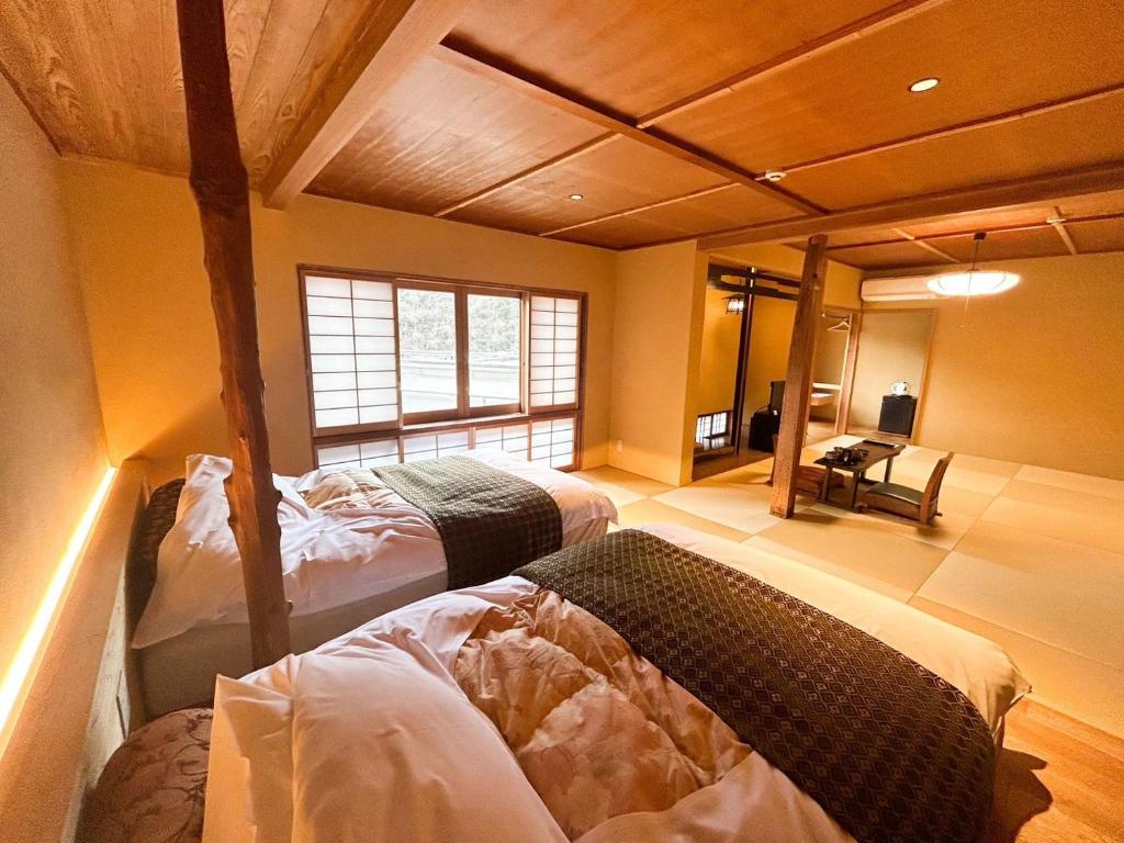 Postel nebo postele na pokoji v ubytování Arifuku Onsen Yoshidaya