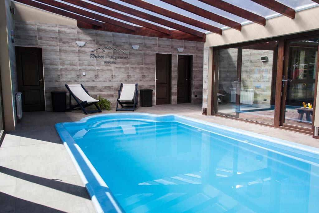 una piscina di fronte a una casa di Complejo Raíces Patagonicas a Dina Huapi