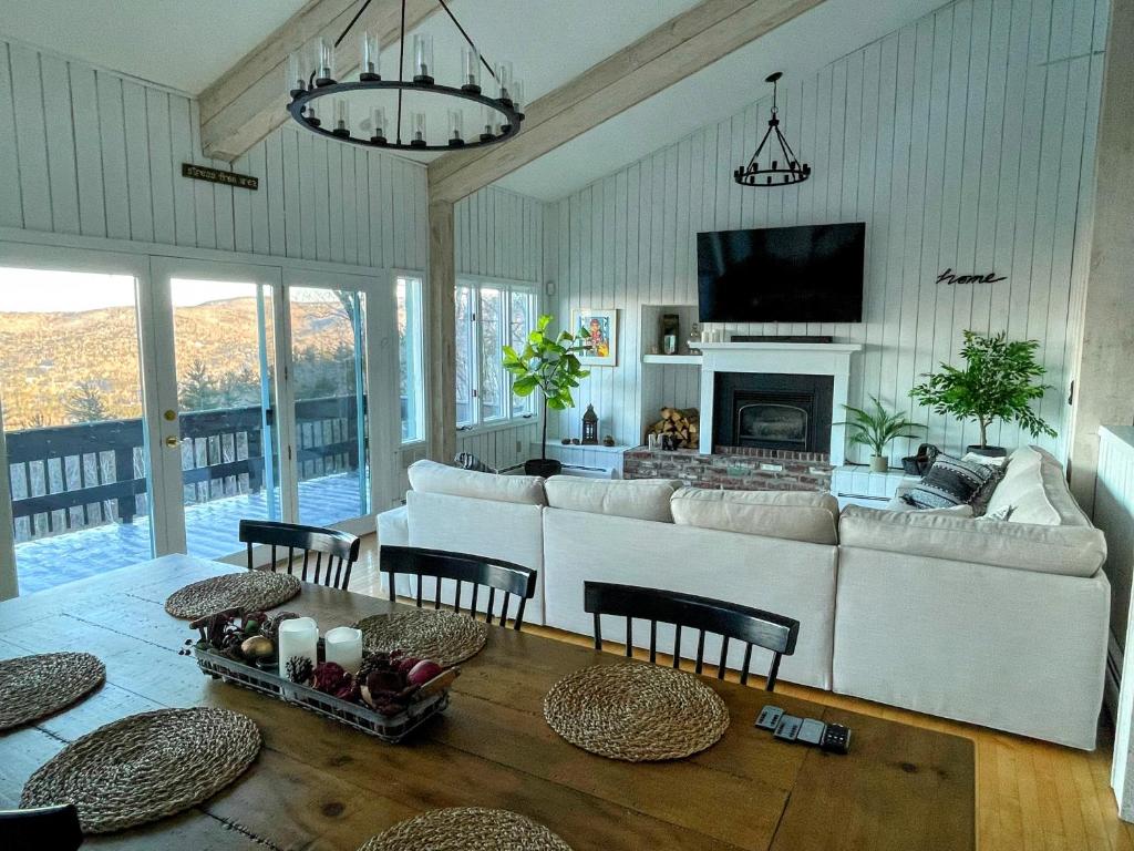 un soggiorno con divano bianco e camino di Amazing View Retreat Home a Campton