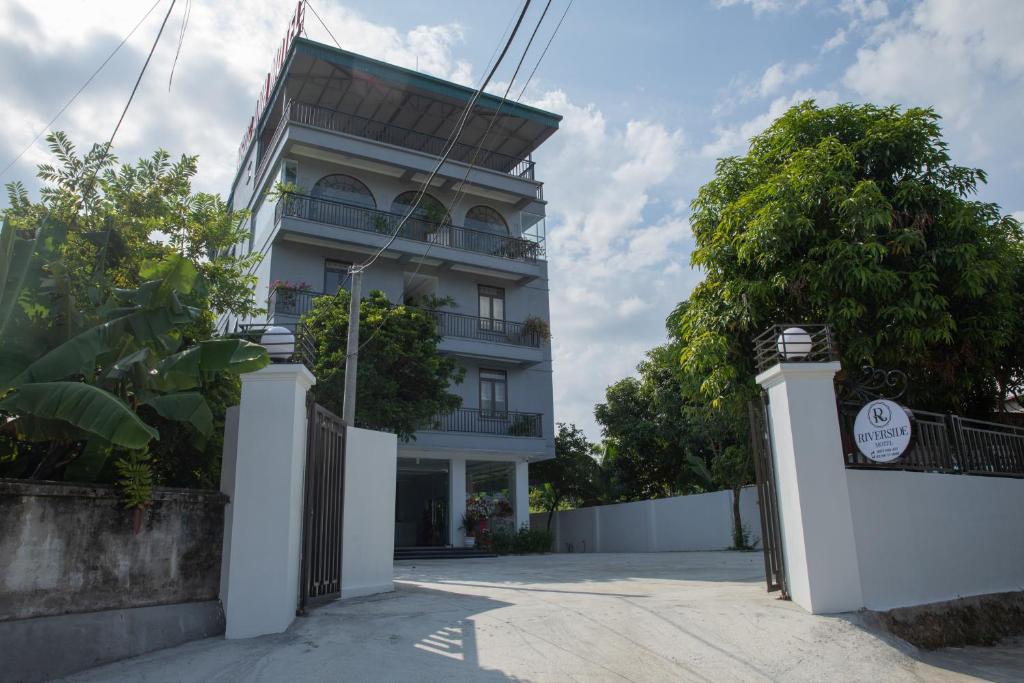 a white building with a gate in front of it at Nhà Nghỉ Ngọc Anh in Nghĩa Lộ