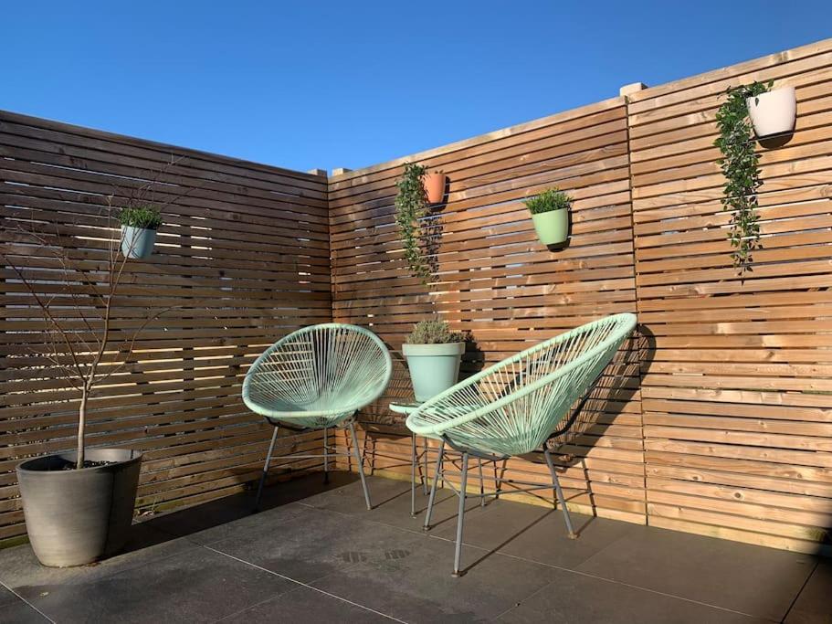 een patio met 2 stoelen en een hek met planten bij Maison en plein centre avec terrasse et jardin in Vielsalm