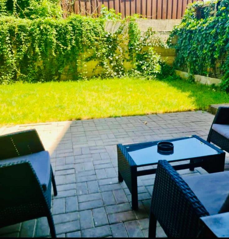 a patio with a table and chairs and a lawn at Apartament Mara in Alba Iulia