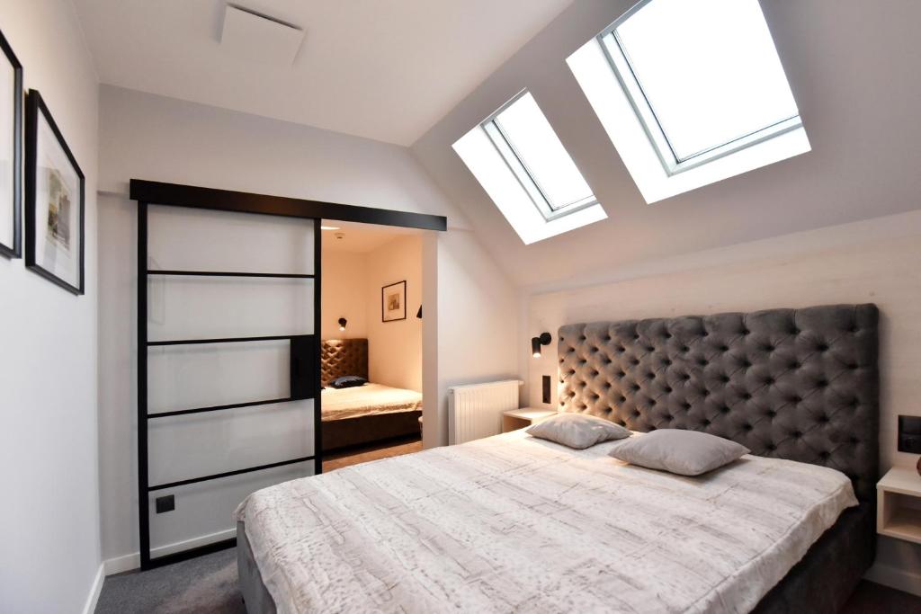 Schlafzimmer mit einem großen Bett und Oberlichtern in der Unterkunft RIVER'S TOUCH Apartament Grand z widokiem na Odrę in Stettin