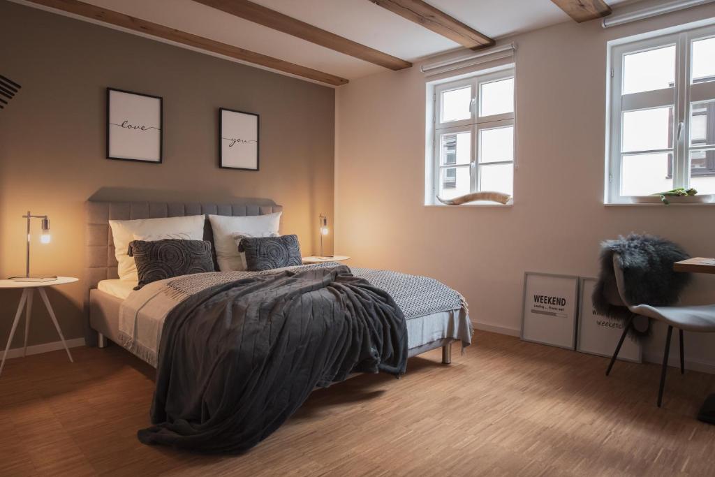 um quarto com uma cama e duas janelas em St. Salvator Apartments em Fulda