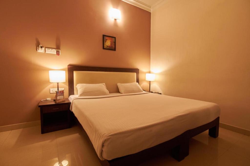 a bedroom with a bed with two lamps on it at Fort Abode in Cochin