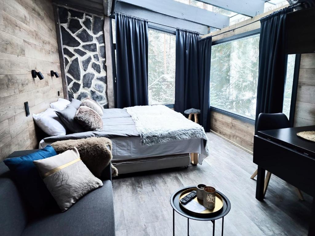 1 dormitorio con 1 cama y 1 sofá en Himosranta Suites, en Jämsä