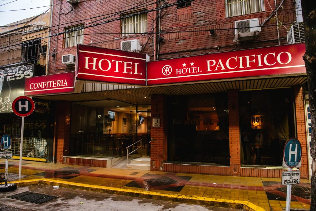 a hotel with red signs on the front of a building at Hotel Pacífico in Mendoza