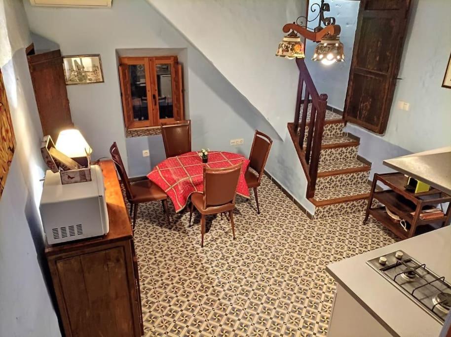 una cocina con mesa y sillas y una escalera en Acogedora casa de pueblo, con todas las comodidades, en Moratalla